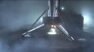 the first stage of a rocket stands on its legs after landing on a ocean-based droneship