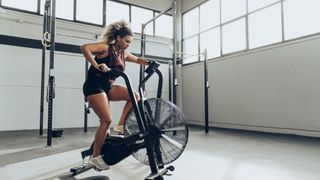Woman doing HIIT workouts on an airdyne bike
