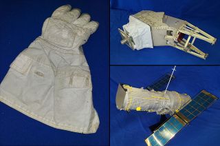 Photo of an astronaut glove, a model of the hubble space telescope and a spare mechanical arm for the viking mars lander