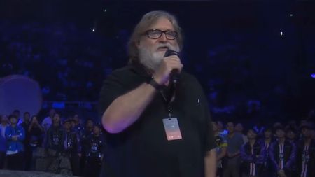 Gabe Newell in a black shirt holding a microphone