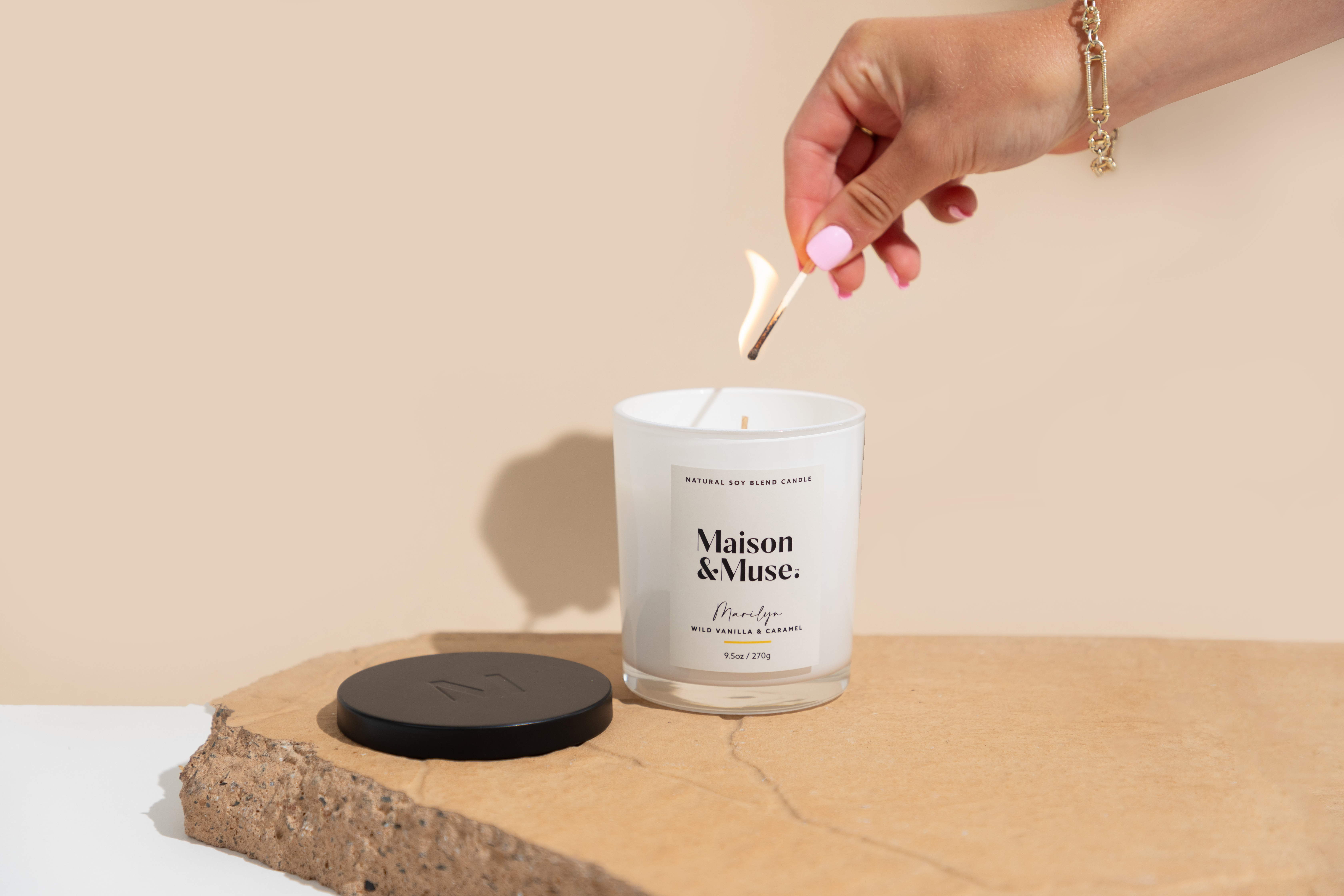 A woman lights a Maison &amp;amp; Muse candle