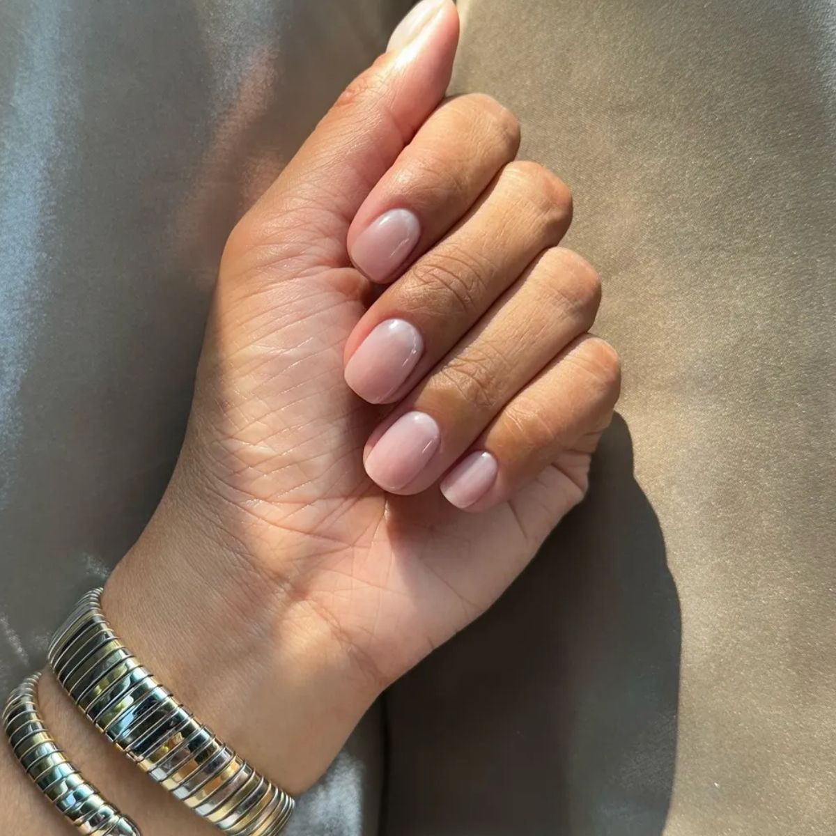 A woman's hand with a natural, glossy manicure