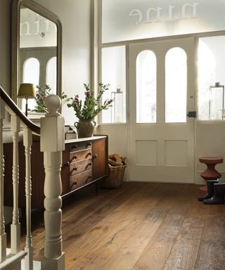 Rustic style engineered wooden flooring in hallway with cream paint
