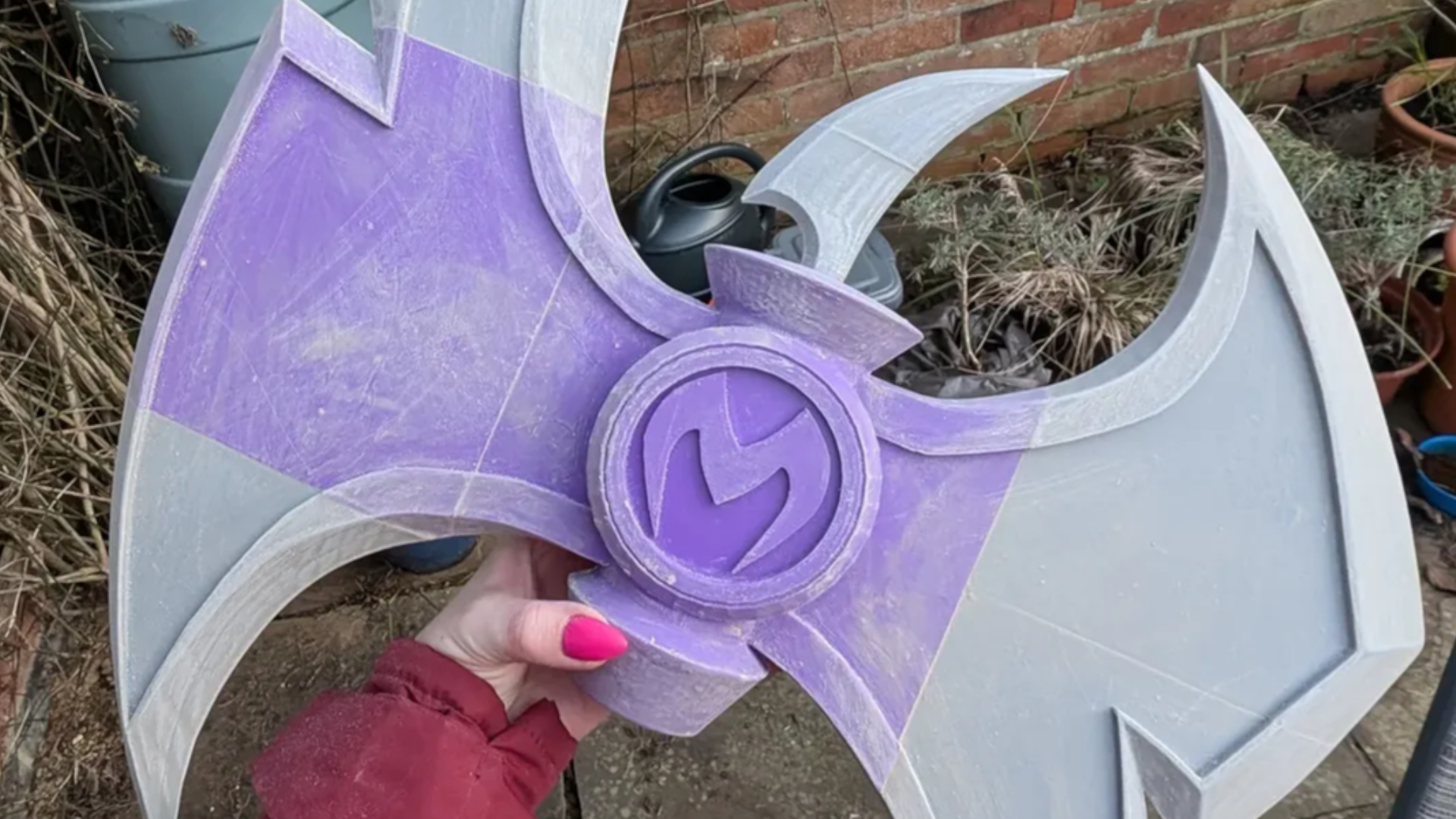 A hand holds a 3D-printed axe head