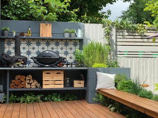 a small outdoor kitchen with a tiled backsplash