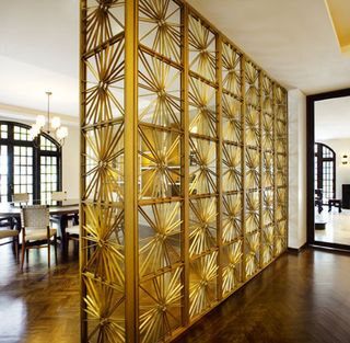 customised brass screen in a sunburst design between the foyer and dining room
