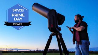 A person standing near a Unistellar Equinox 2 telescope, in a field, with a Space Prime Day deals badge to the left.