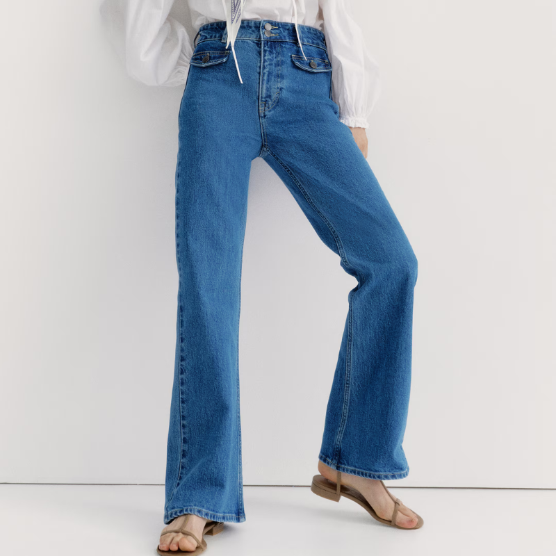 A woman wearing high-waisted flared jeans and sandals