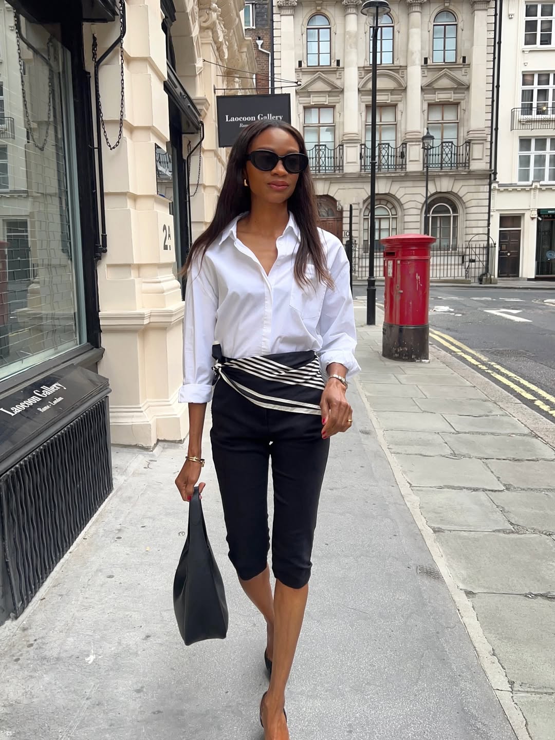 @symphonyofsilk wearing a white shirt and capri pants