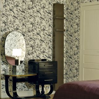 tall radiator in bedroom with patterend wallpaper and decorative vanity table