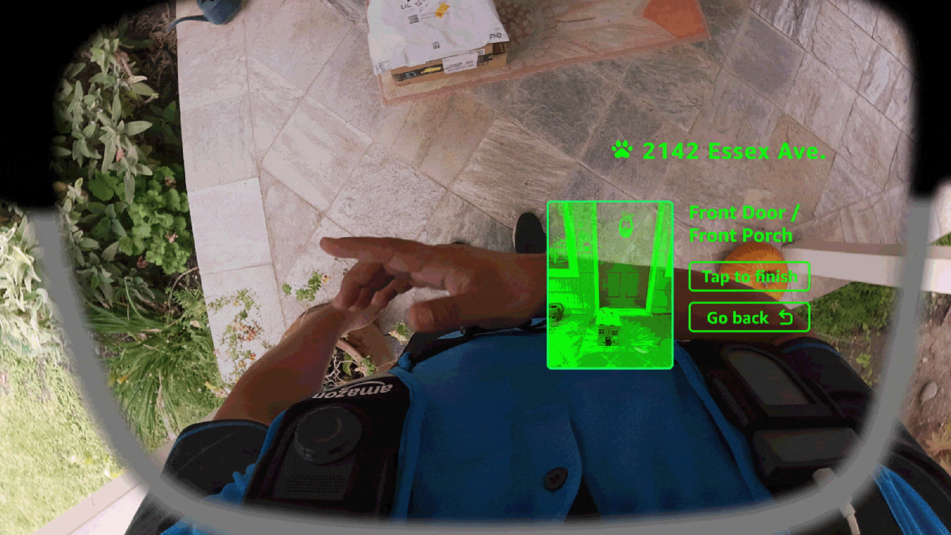 A delivery driver using the vest-mounted photo button of the Amazon Amelia smart glasses