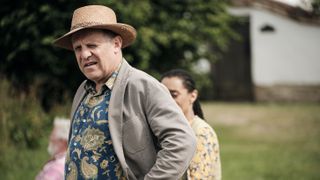 Nigel Lindsay in a straw hat and grey jacket as Nigel Bellamy in Midsomer Murders