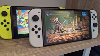 Two Nintendo Switch OLED consoles on a desktop