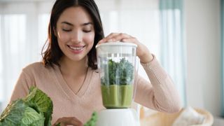 Woman making green smoothie