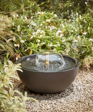 a small bowl shaped water feature in a gravel garden