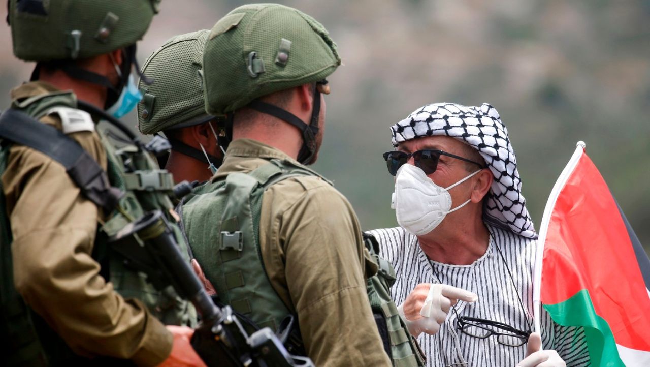 A Palestinian protester confronts Israeli forces 