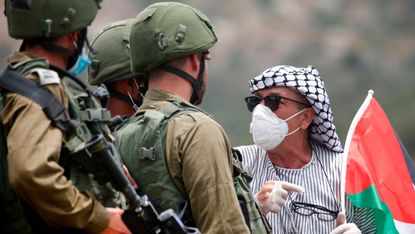 A Palestinian protester confronts Israeli forces 