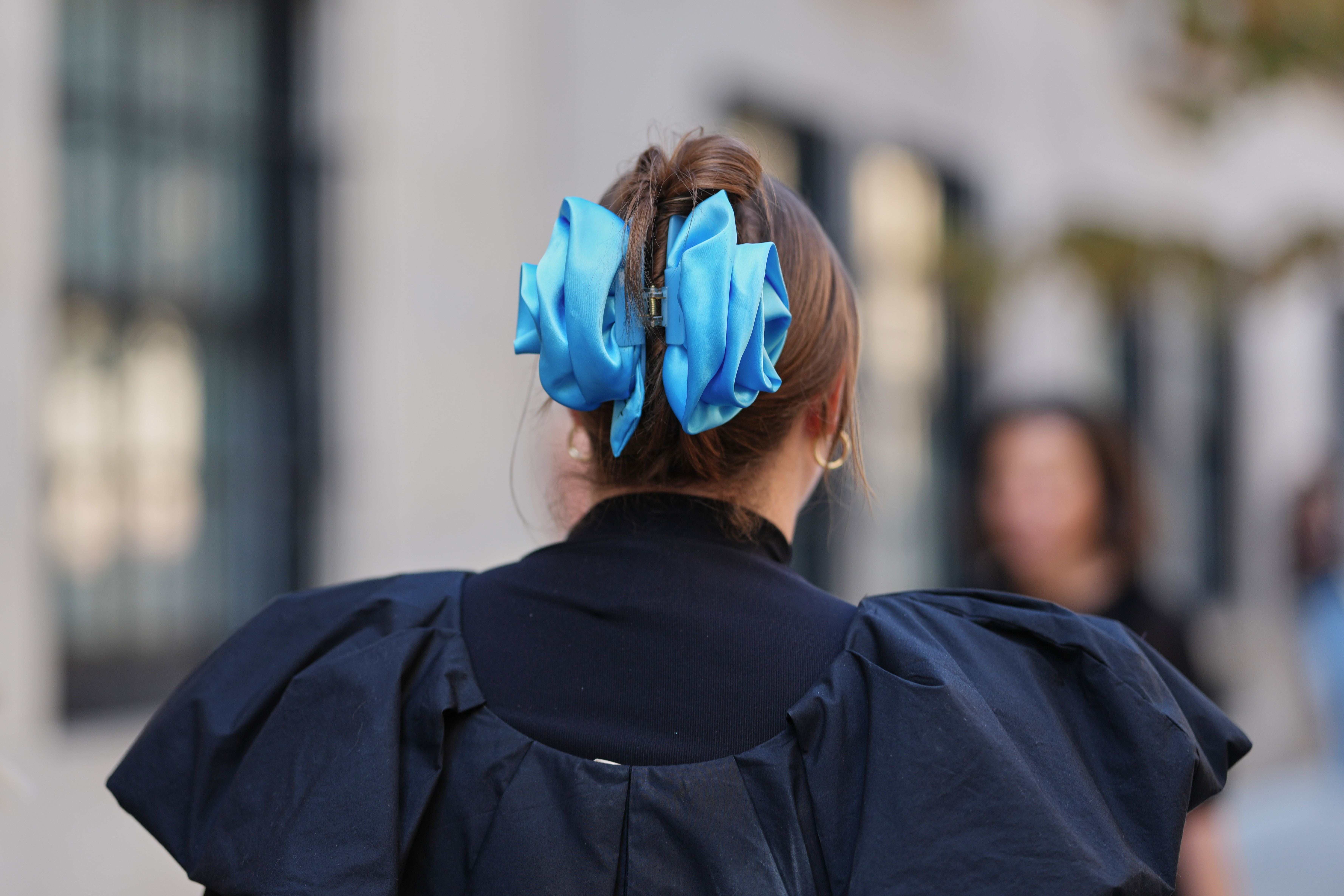 person wearing a large sky blue floral shaped claw clip