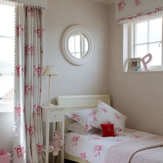 Childs bedroom with pink patterned curtains and bedlinen