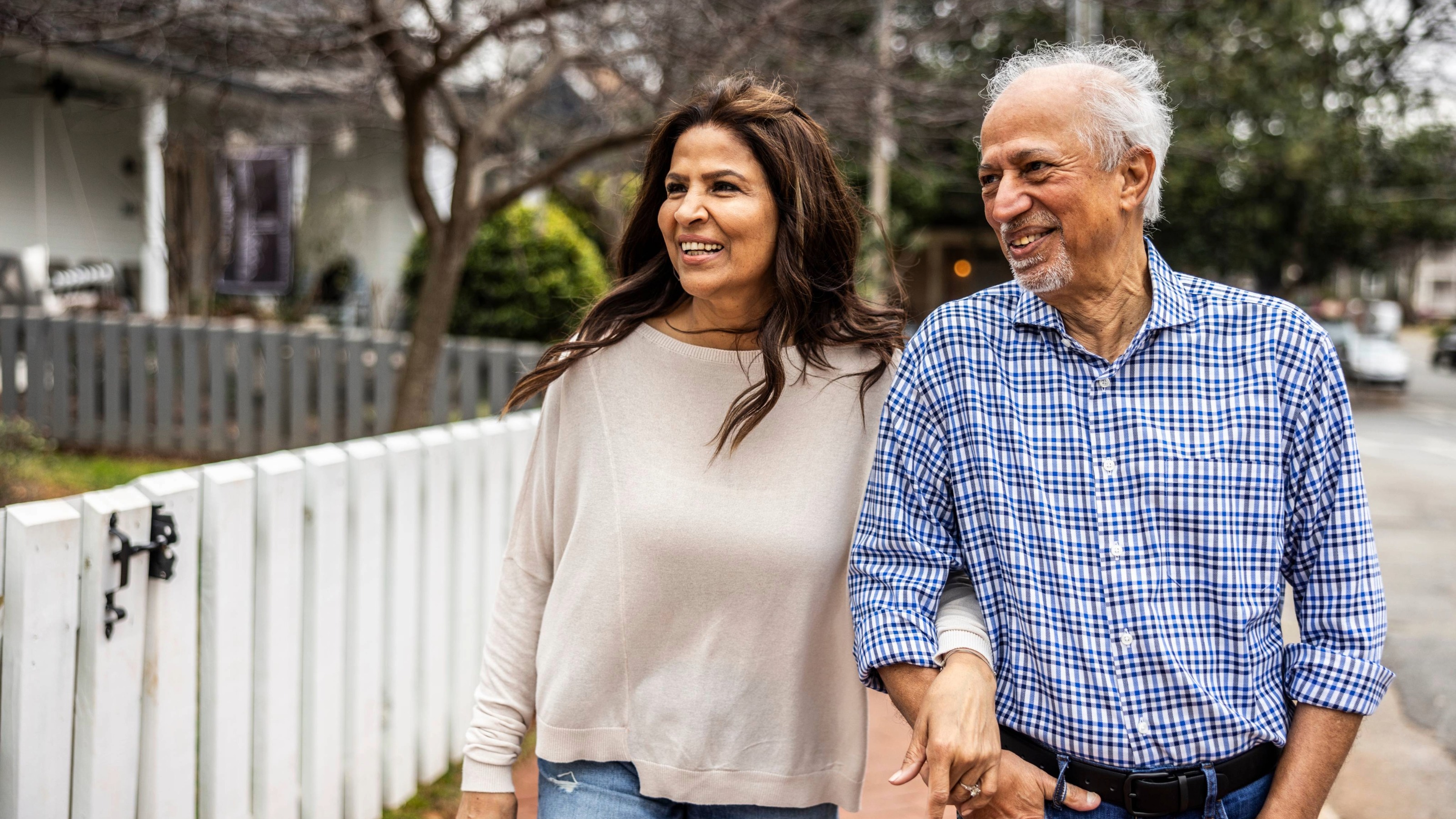 Happy senior couple walk down suburban street