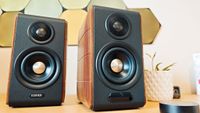 Black and brown Edifier S880DB MkII speakers on a wooden desk