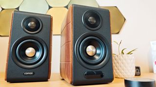 Black and brown Edifier S880DB MkII speakers on a wooden desk