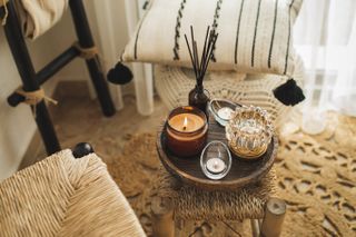 Home decoration with burning candles on wooden coffee table in bright and cozy living room