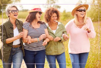 Group of female friends linked arms and laughing