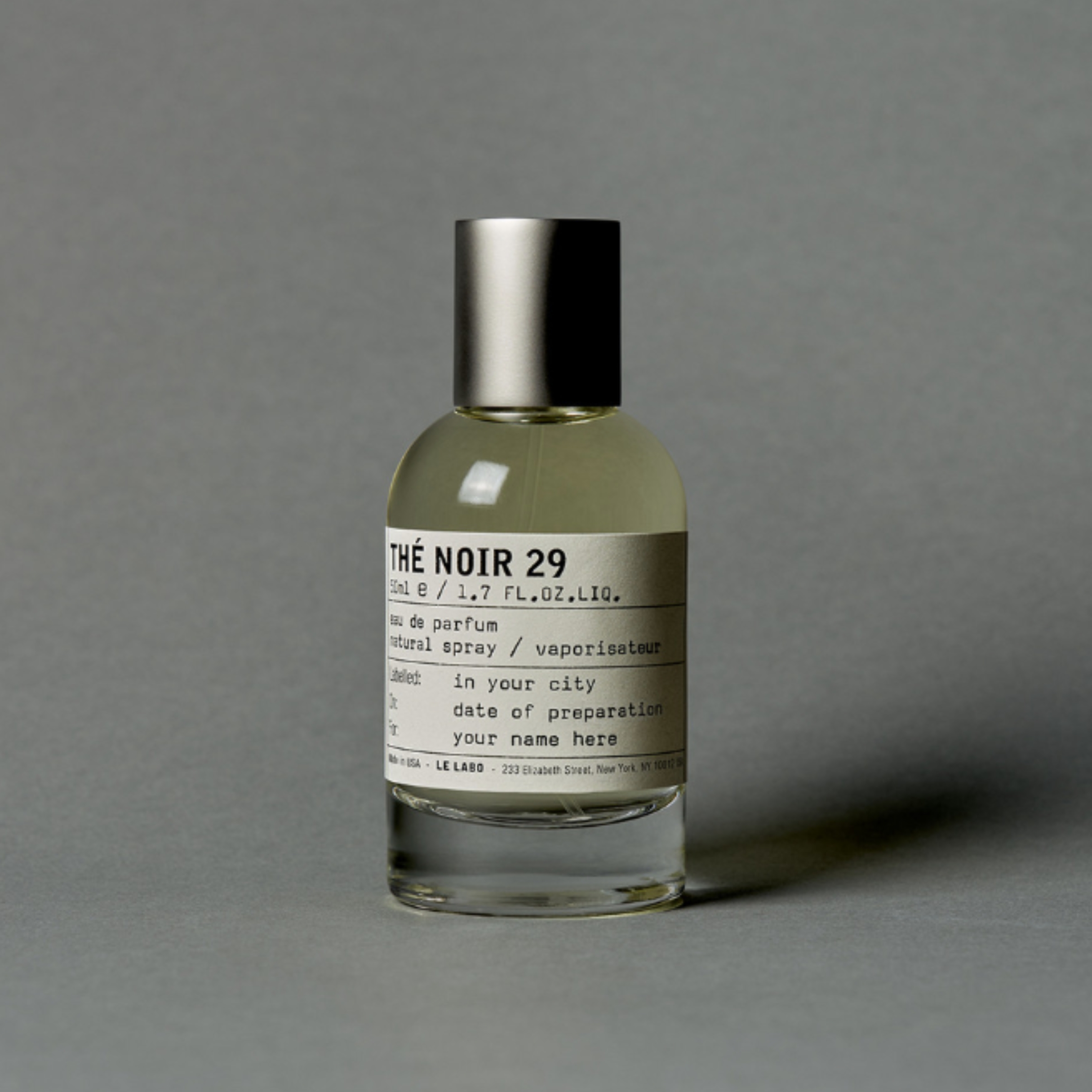 A product shot of the Le Labo TH&amp;Eacute; NOIR 29 eau de parfum, on a grey background
