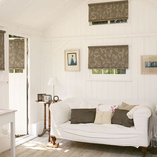 living room with white wooden wall white sofa and wooden flooring