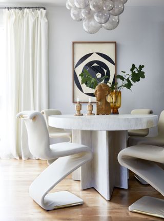 Round dining table and angular chairs in a white dining room