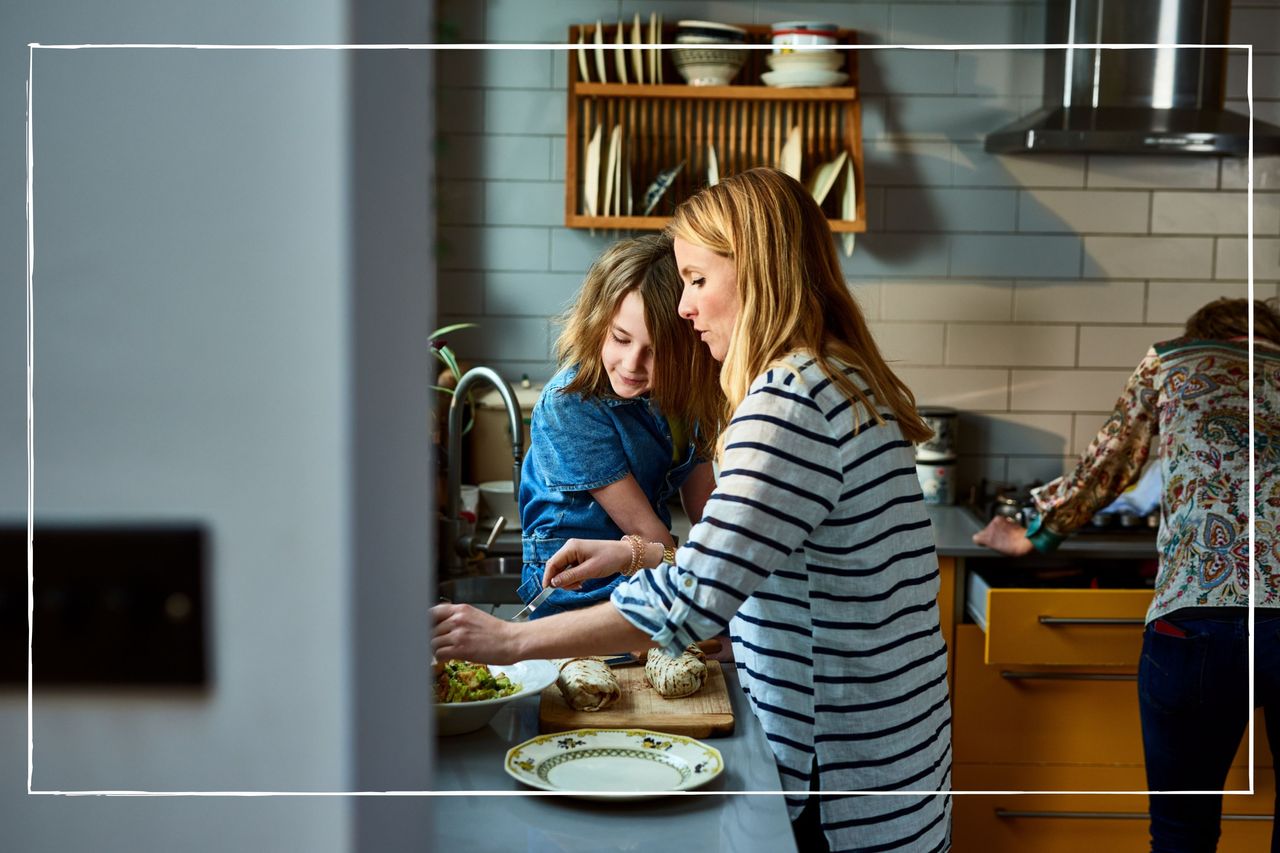 mother cooking food with young daughter at home in the kitchen