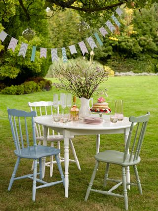 chairs and table on lawn painted in pastel hues from Sandtex