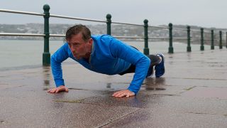 Man performs press-up exercise outside