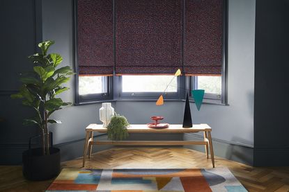 ways to make your house feel warmer including draft curtains and blinds in a dark living room