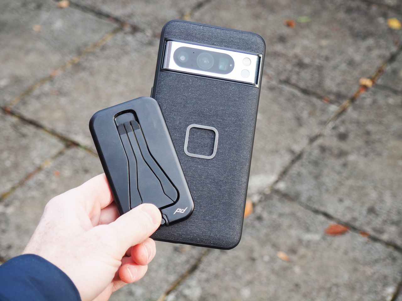 Peak Design Mobile Tripod folded away, in user's hand alongside a Pixel phone with Peak Design's dedicated case