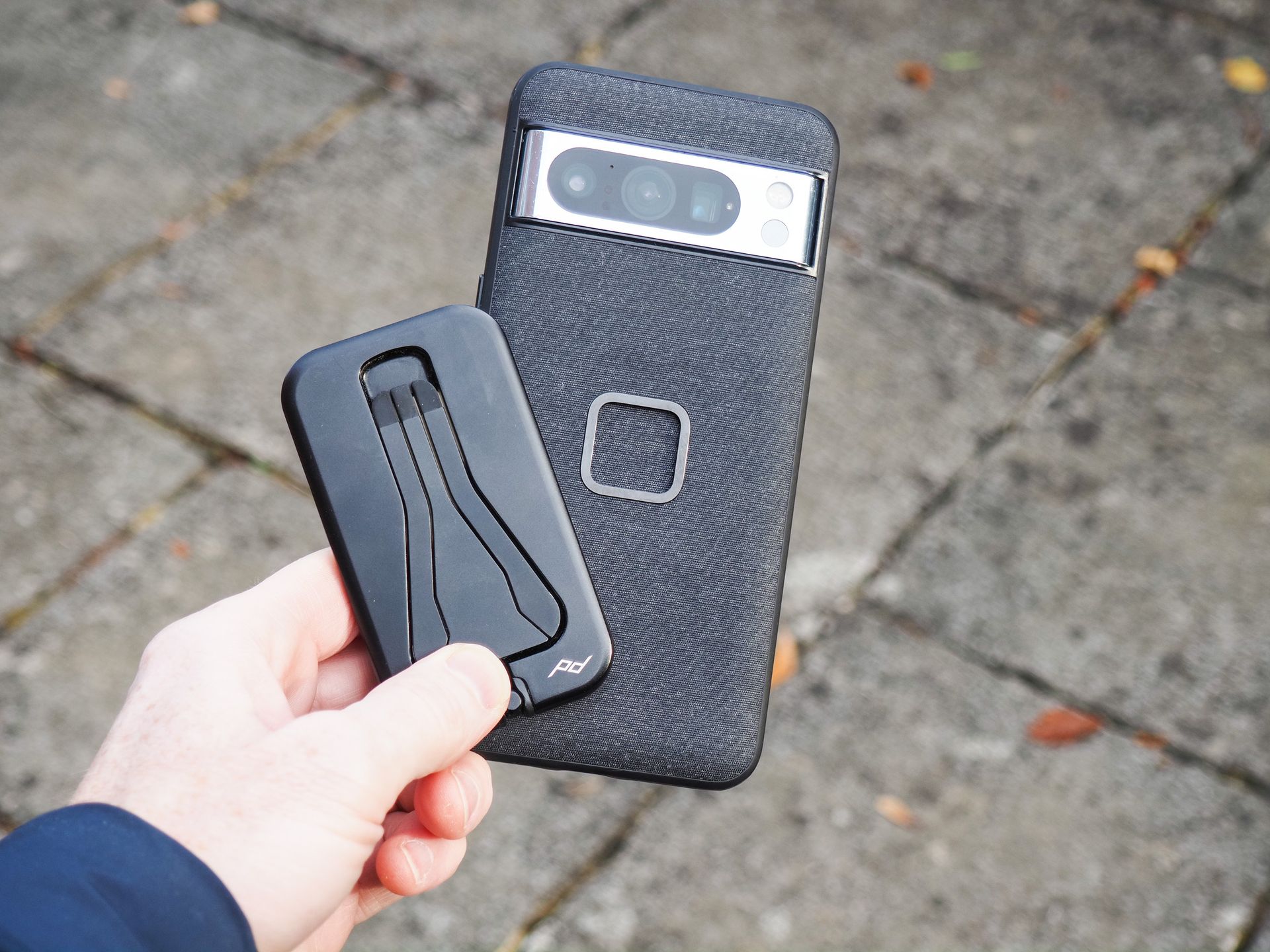 Peak Design Mobile Tripod folded away, in user's hand alongside a Pixel phone with Peak Design's dedicated case
