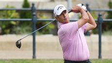 Ian Baker-Finch holds his finish on a drive while wearing a pink polo and white Callaway cap