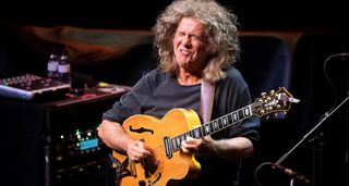 Pat Metheny grimaces as he plays his signature Ibanez jazz box onstage in Spain