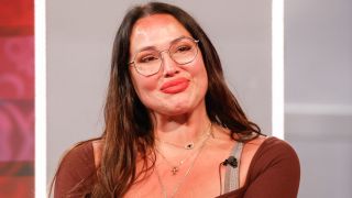 Amy Bingham smiling on the Big Brother stage. 