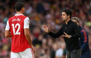 Arsenal manager Mikel Arteta speaks to William Saliba during the Premier League match between Arsenal FC and Liverpool FC at Emirates Stadium on October 09, 2022 in London, England.