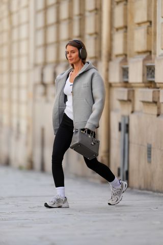 woman wearing tank, sweatshirt, leggings, and sneakers