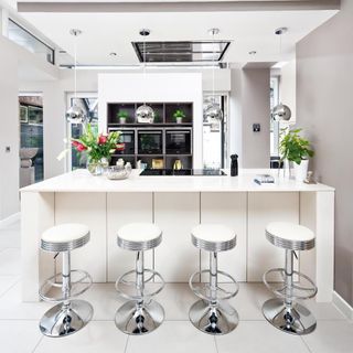 kitchen with white counter and white bar stools