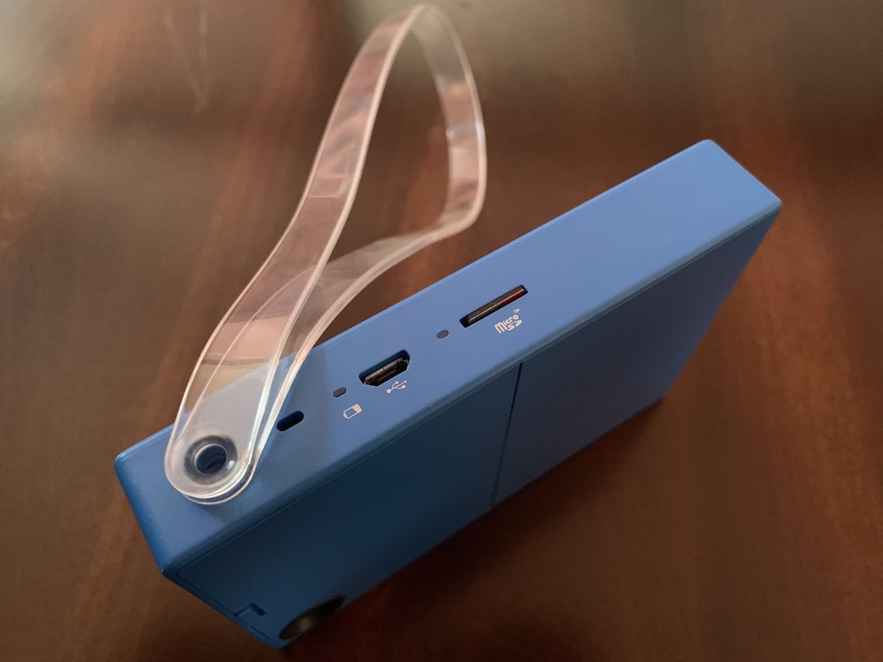 Blue Polaroid Mint Camera &amp; Printer side with clear plastic lanyard, power light, and microSD card slot