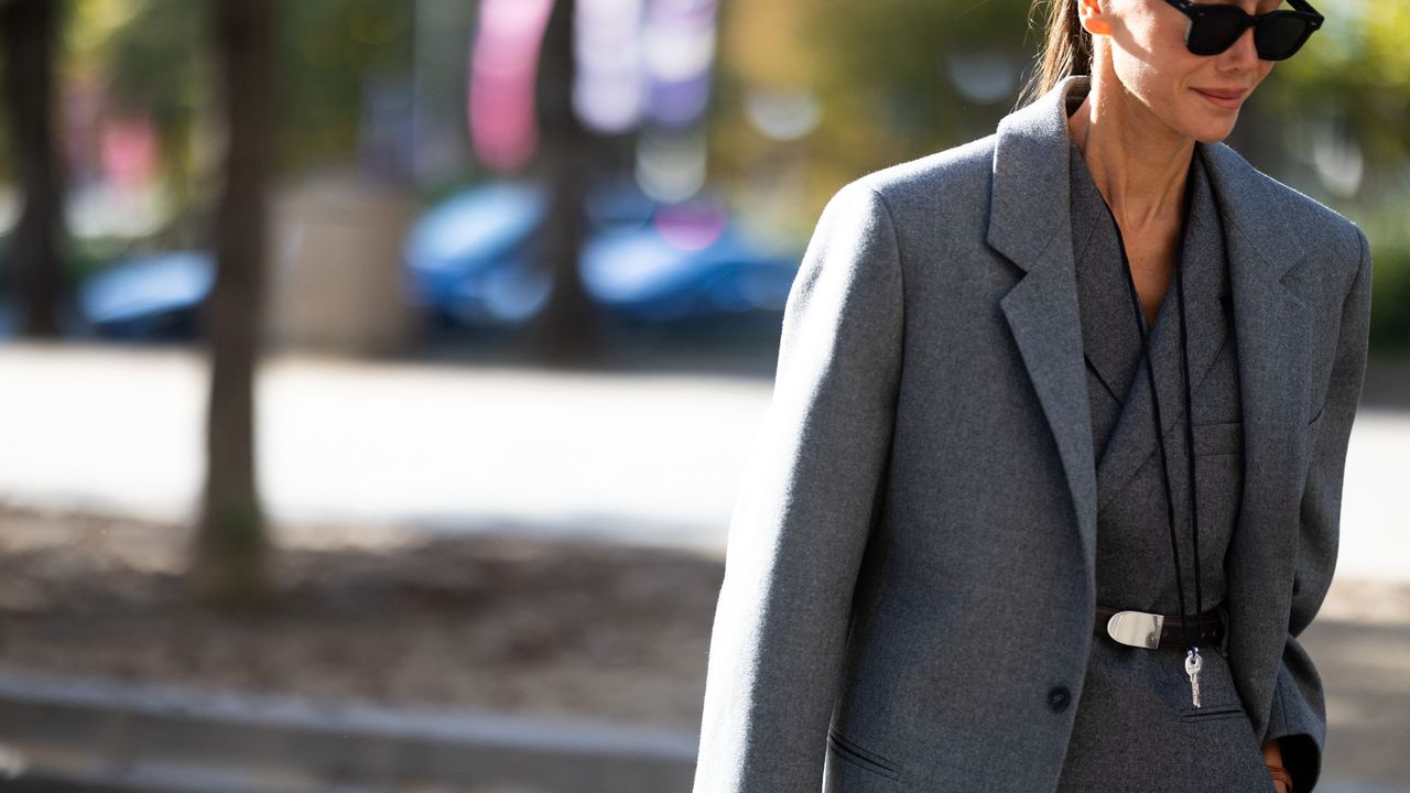 A woman wearing an expensive-looking power suit, fitting for an intense perfume