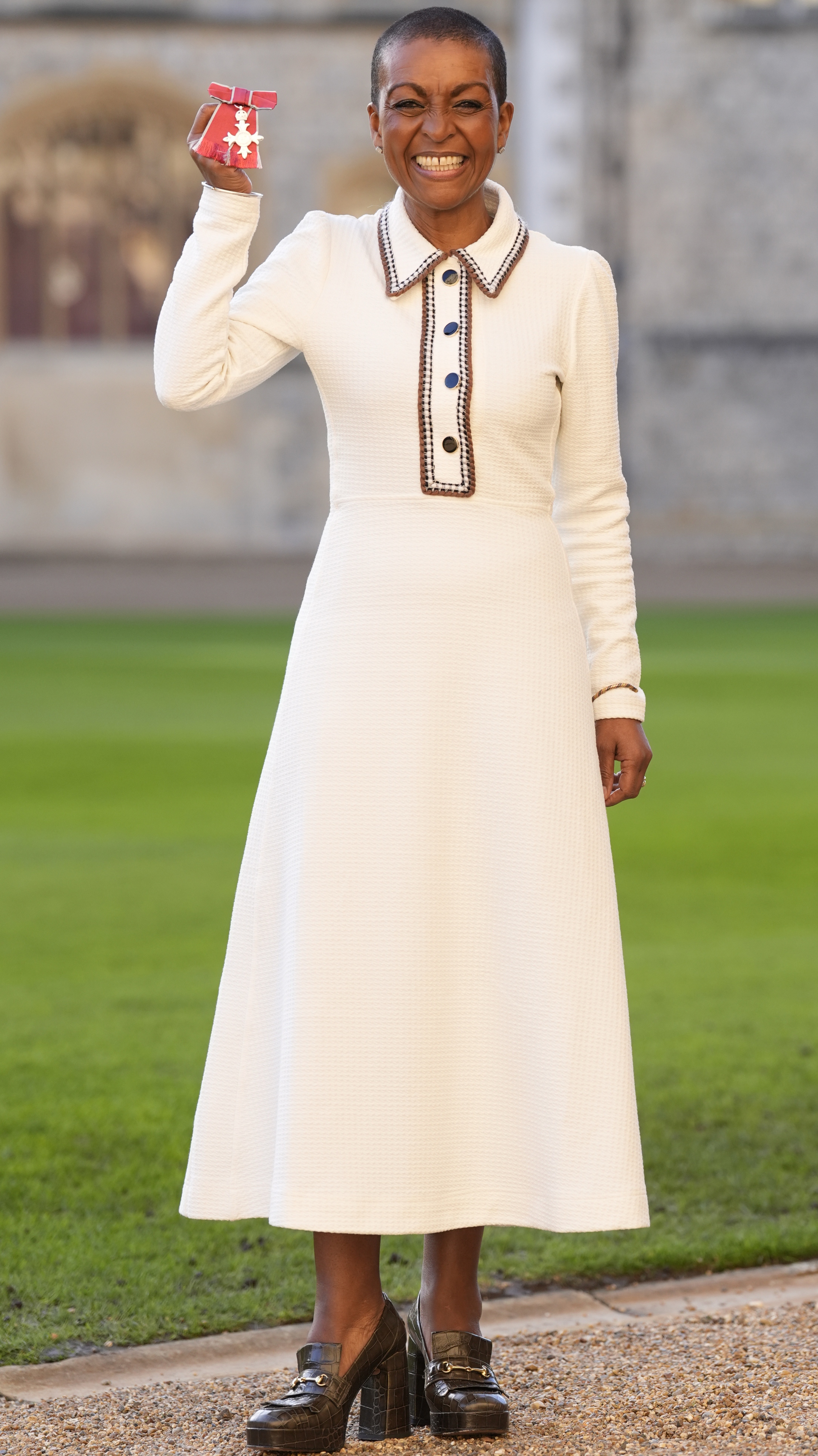 Adjoa Andoh smiles and holds up her MBE after being made a Member of the Order of the British Empire (MBE) by the Prince of Wales during an investiture ceremony at Windsor Castle on December 10, 2025