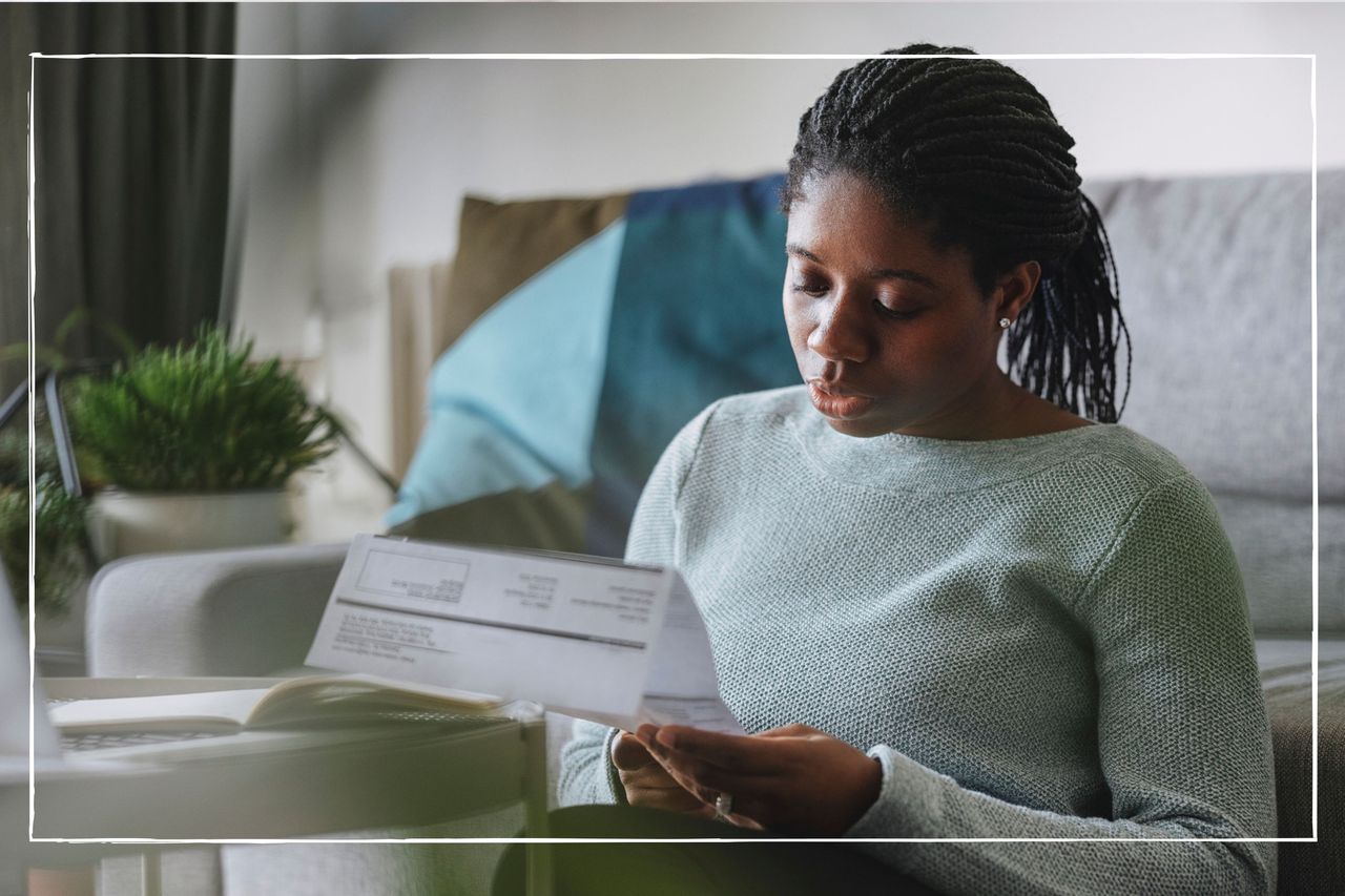 woman sat on floor at home looking at utility bills