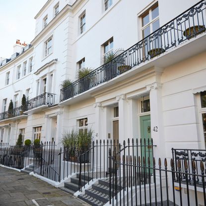 Exterior shot of terraced white buildings with black railings