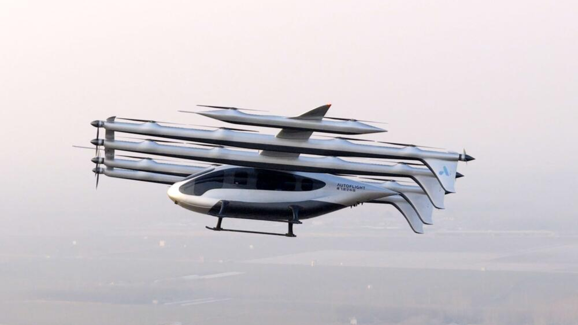 A sleek silvery aircraft flies over a smoggy cityscape with multiple propellors and tails.