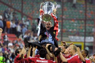 Bayern Munich coach Ottmar Hitzfeld holds the Champions League trophy as he is lifted in the air by his players following the club's win in the final against Valencia in May 2001.